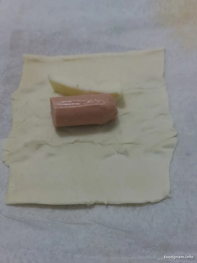 wurstel e bastoncino di formaggio sul quadrato di pasta sfoglia